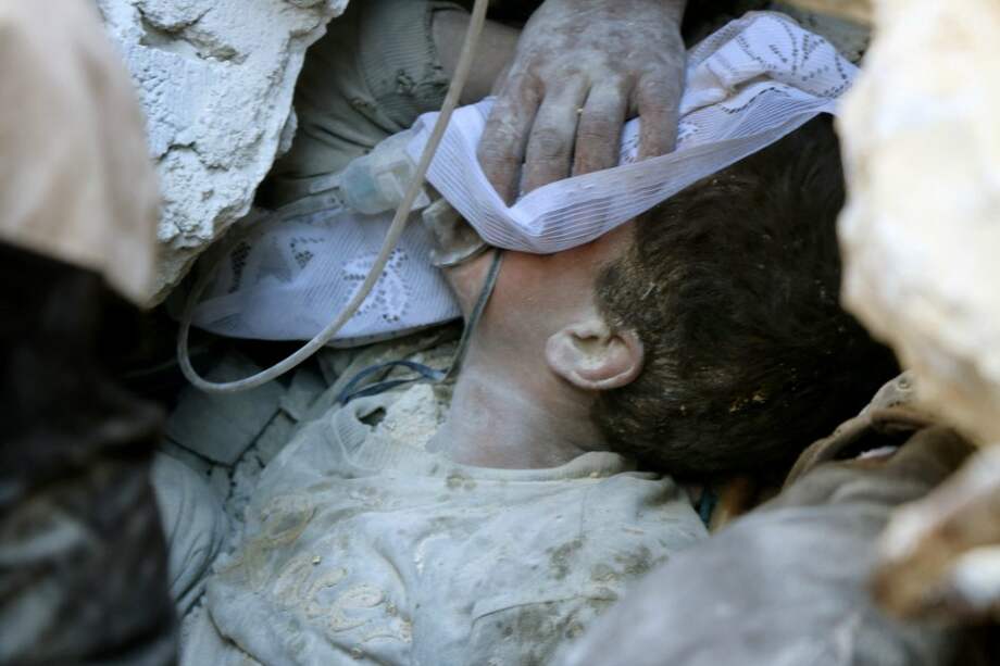 Un niño es rescatado de los escombros de una edificio en Alepo, tras un bombardeo ruso esta semana. / AFP
