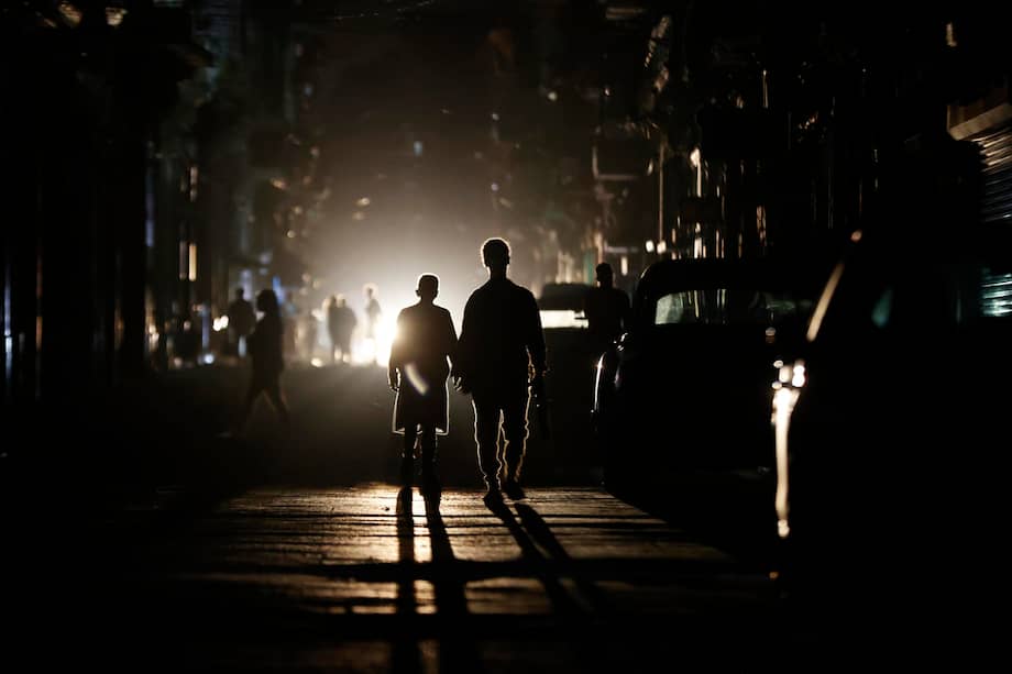 Personas caminan por una calle sin electricidad este sábado, en La Habana (Cuba).