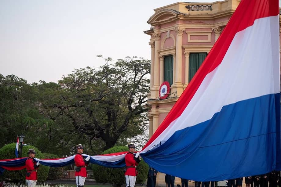 Personal de la Guardia Presidencial iza la bandera paraguaya este jueves en el Palacio de Gobierno en Asunción (Paraguay). / EFE