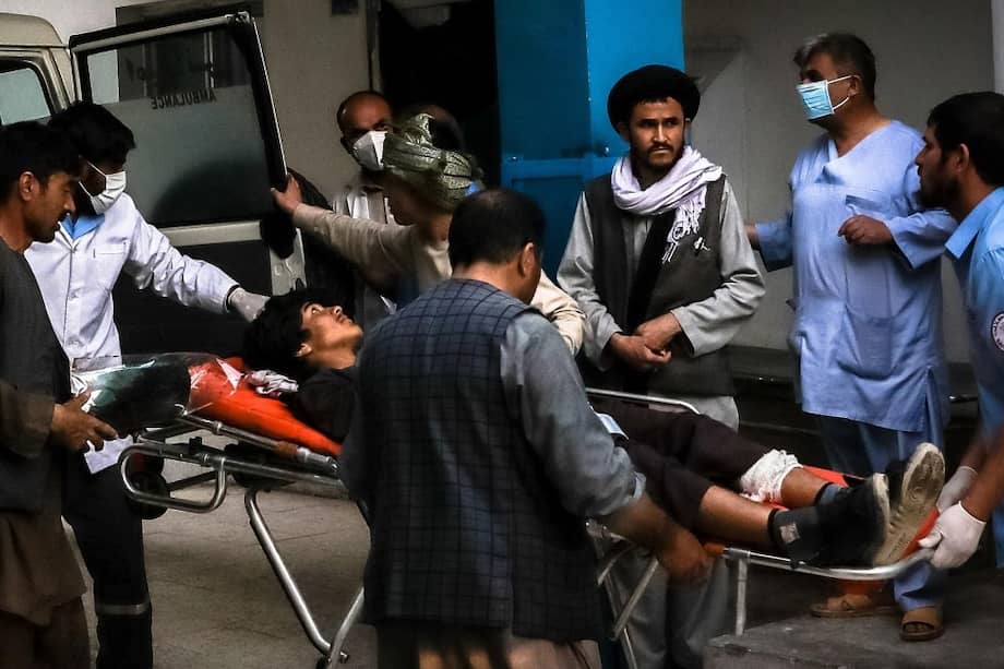 Personas llevan a un hombre herido a un hospital después de la explosión en el centro de Kabul, Afganistán.