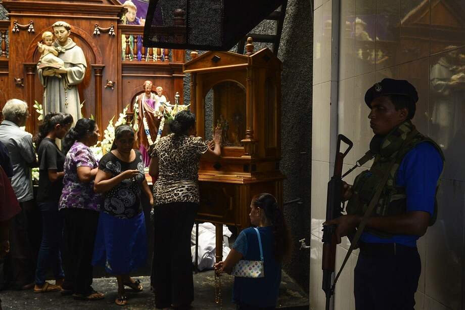 Devotos católicos rezan en la iglesia de San Antonio, parcialmente reabierta por primera vez este martes desde los atentados del Domingo de Resurrección, bajo fuertes medidas de seguridad. / EFE