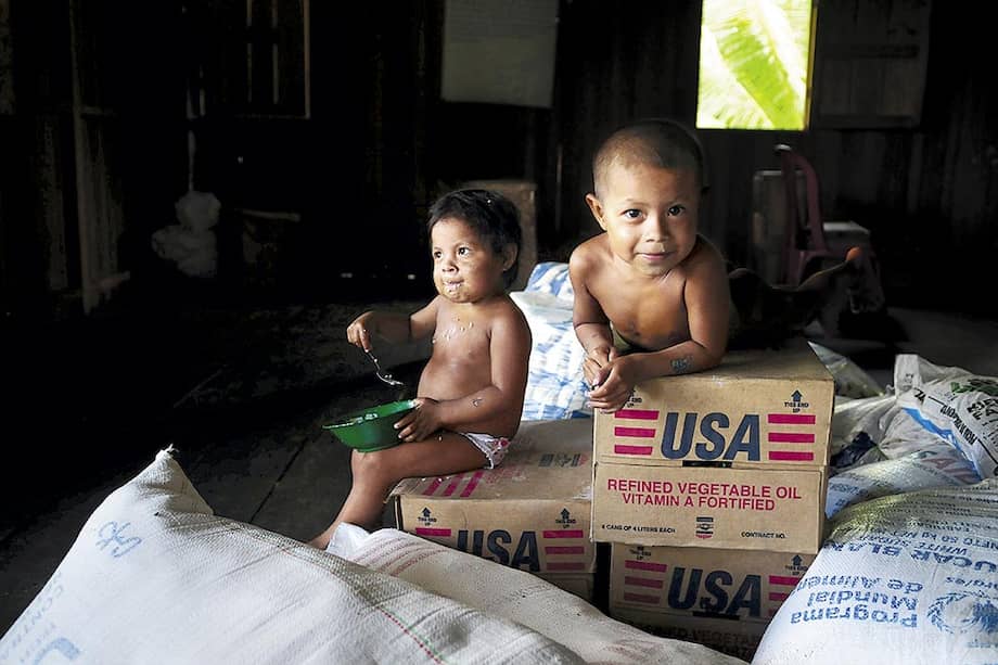 Los menores indígenas son particularmente vulnerables al drama de la desnutrición. En la foto, dos niños emberas de Nariño sentados sobre ayuda humanitaria. / Nelson Sierra G.