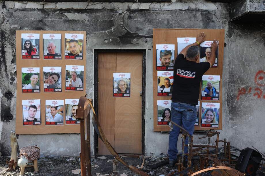 Un hombre colgó fotografías de rehenes de Hamás en Gaza, en una casa incendiada en el kibutz Beeri, cerca de la frontera de la Franja, en el sur de Israel.
