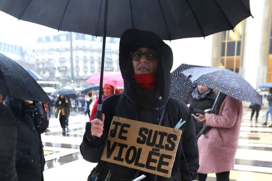 Una mujer lleva carteles que dicen "Soy violada. Gracias. Yo también" en París. / AFP