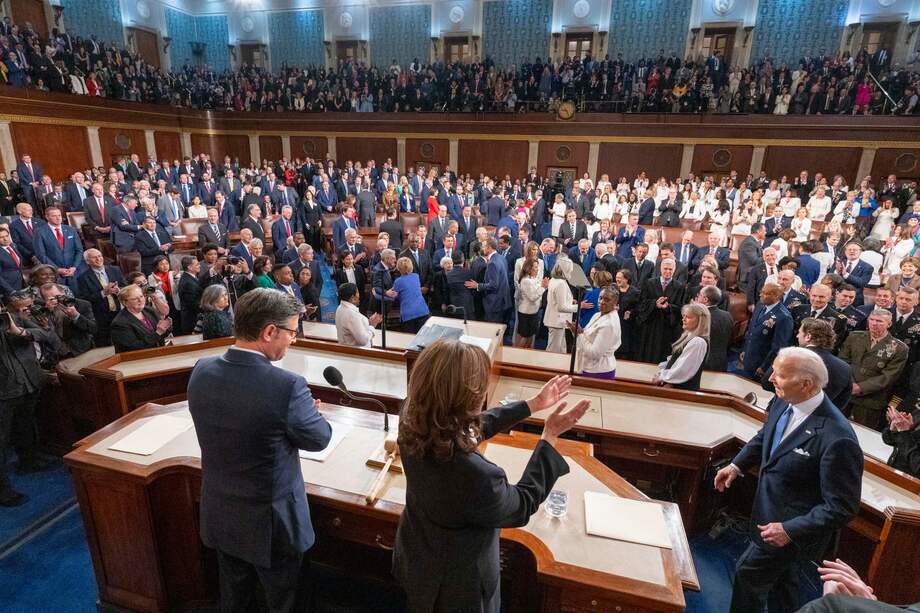 El presidente de la Cámara de Representantes, Mike Johnson (I), y la vicepresidenta de EE. UU., Kamala Harris, reciben al presidente Joe Biden para su discurso en el Capitolio.
