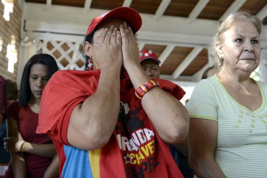 Un grupo de mujeres se lamenta de la muerte del presidente Hugo Chávez. / AFP