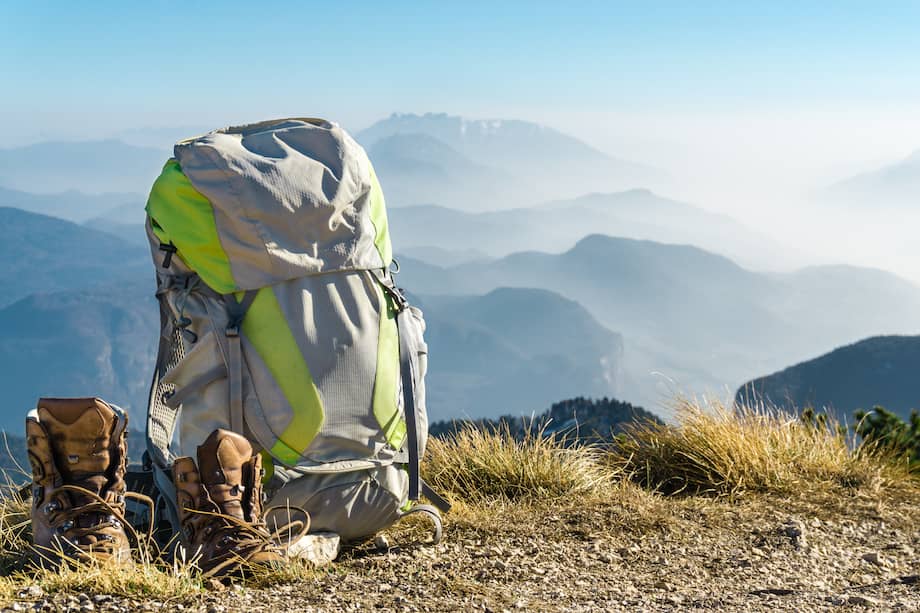 Hiking equipment. Backpack and boots on top of the mountain.