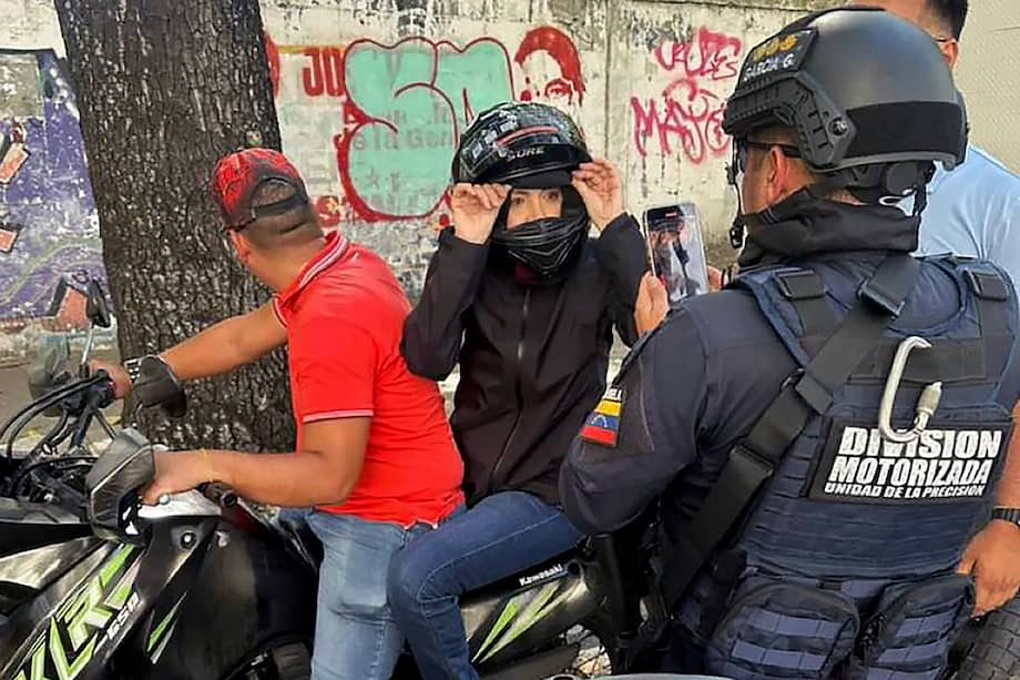 Fotografía difundida por Agencia Venezuela News que muestra a la líder opositora venezolana María Corina Machado siendo filmada por un oficial de la Policía Nacional después de pronunciar un discurso durante una manifestación convocada por la oposición en vísperas de la investidura presidencial, en Caracas el 9 de enero de 2025.