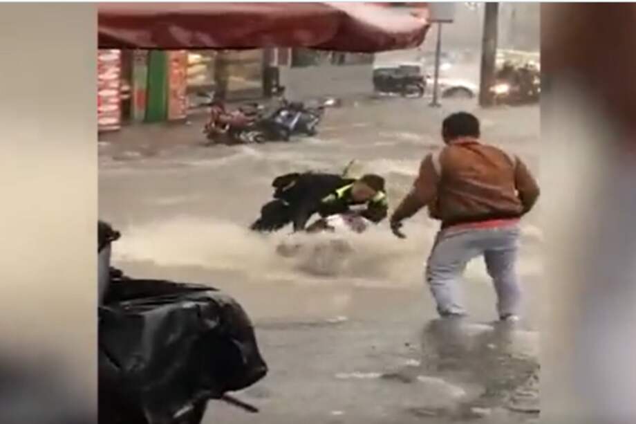 La mujer cayó de su motocicleta debido a la fuerte corriente de agua causada por las lluvias en Bogotá.