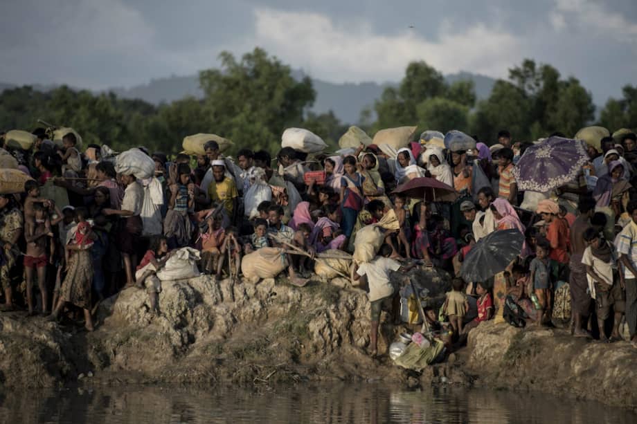 En esta foto tomada en octubre de 2017 se muestra a los rohinyás llegando al río Whaikyang, borde de Bangladesh, donde establecieron un refugio para huir de los crímenes del ejército de Birmania. / AFP