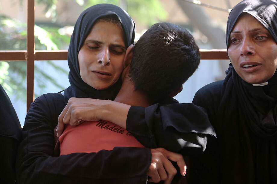 Una mujer abraza a un niño y reacciona tras identificar el cuerpo de un familiar en el hospital Nasser, entre los palestinos muertos en los ataques israelíes en el campo de refugiados de al-Mawasi.
