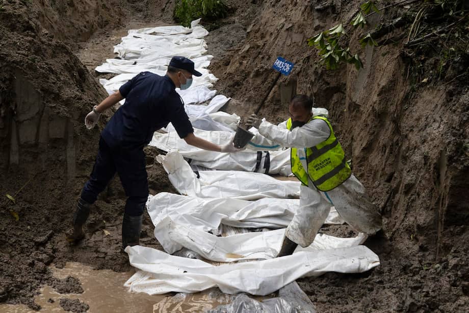 Personal de la policía nepalesa realiza un entierro masivo para las víctimas de las inundaciones en el bosque de Gokran en Katmandú, Nepal.