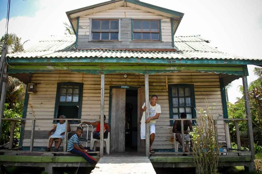 Una familia raizal frente a su tradicional casa de madera en la Isla de San Andrés. / Luis Ángel - El Espectador