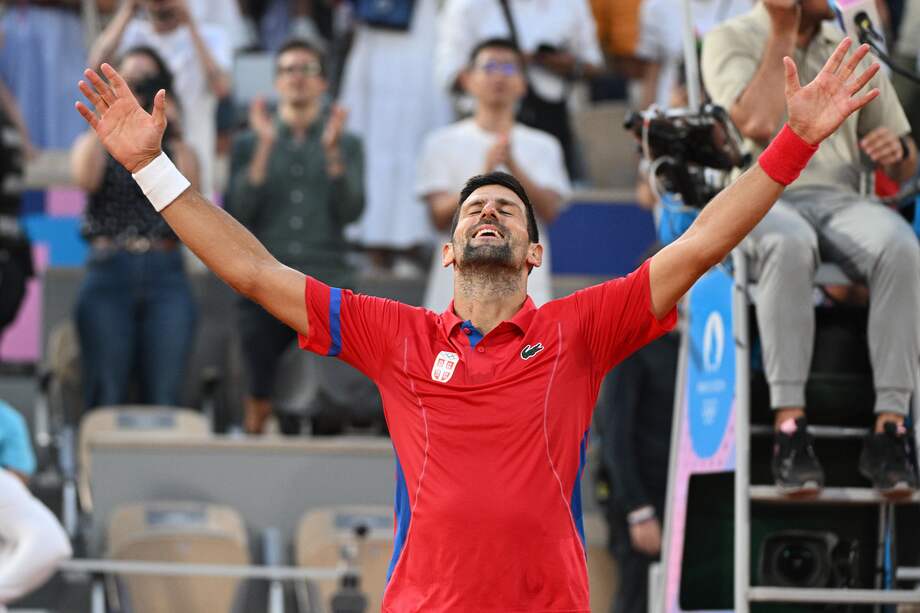 Novak Djokovic celebrando su victoria con las manos al cielo después de derrotar a Lorenzo Musetti de Italia durante la semifinal del torneo de tenis de los Juegos Olímpicos París 2024.