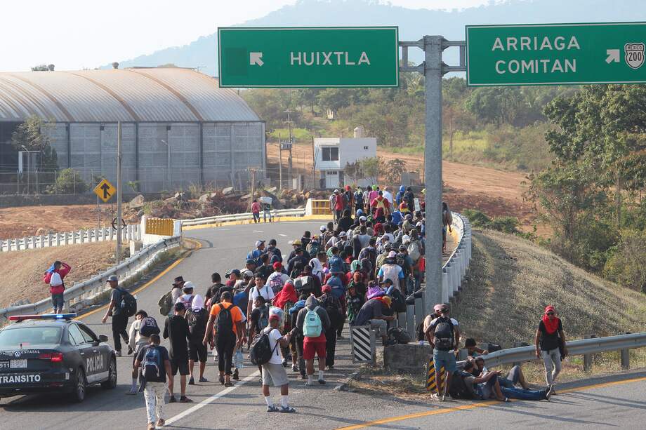 Migrantes caminan en una caravana en una carretera de la ciudad de Huixtla (México).