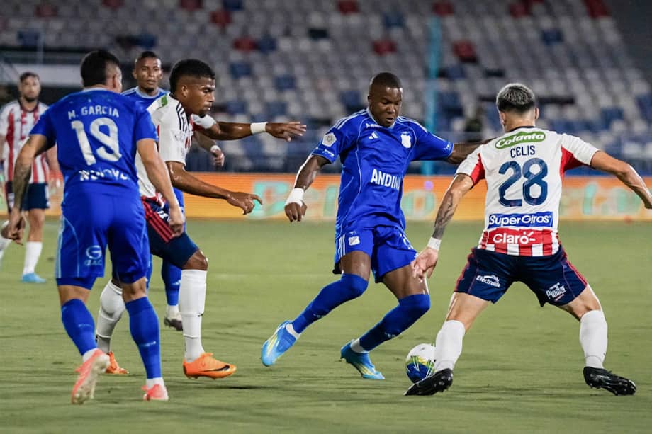 Francisco Chaverra (Millonarios) disputa una pelota con Guillermo Celis (Junior) en el Romelio Martínez de Barranquilla.