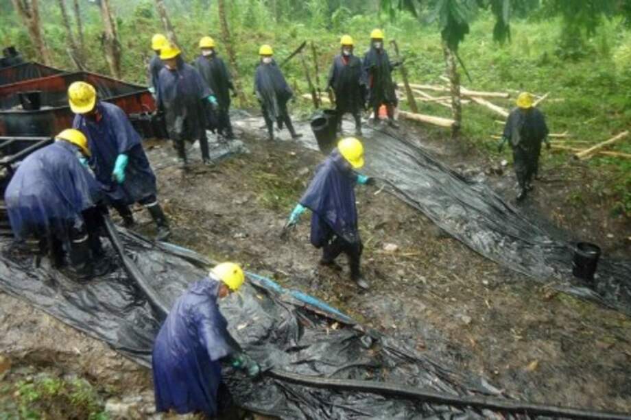 Trabajadores limpian un derrame de petróleo en la amazonia peruana.