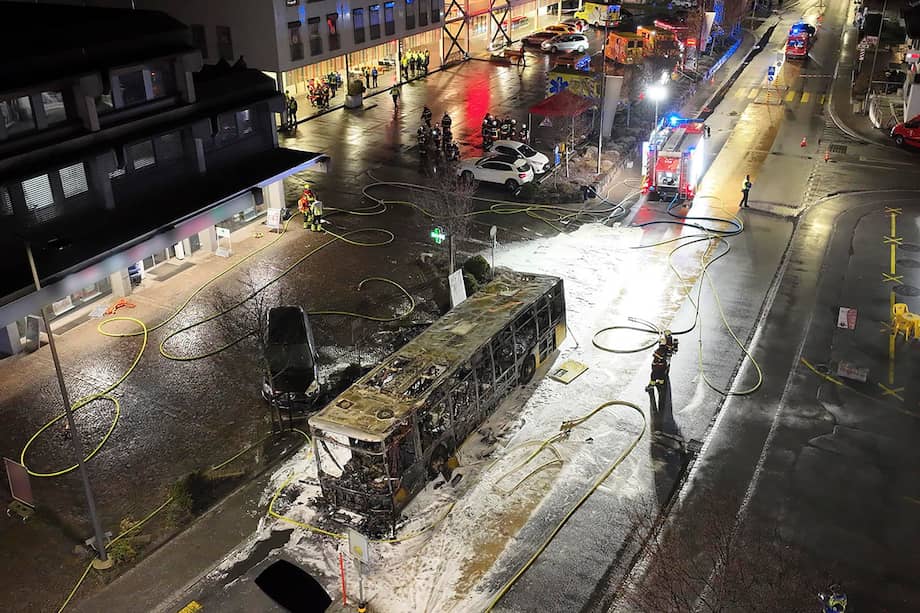 Los investigadores de incendios examinan la carrocería carbonizada de un autobús postal que se quemó en Kerzers, Suiza.