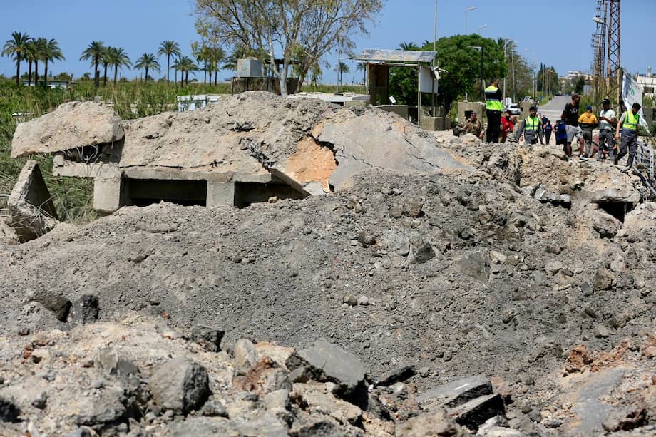 Varias personas cruzan un tramo dañado del puente de Qasmiyeh, blanco de un ataque aéreo israelí cerca de Tiro, en el sur del Líbano.