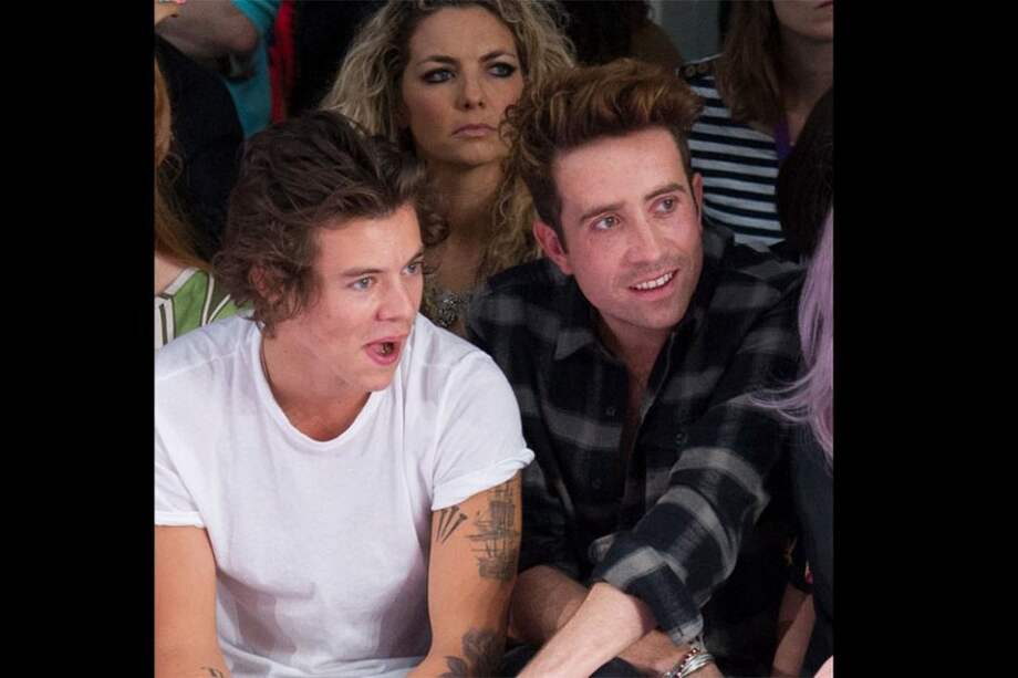 Harry Styles junto a Nick Grimshaw en un desfile de moda.