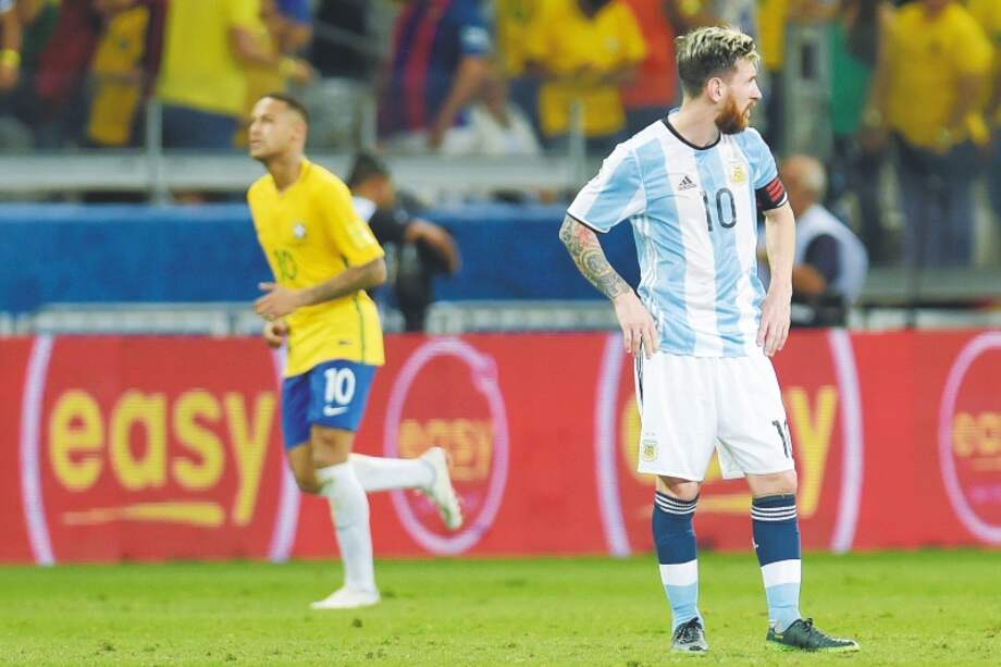 Neymar celebra el segundo gol brasileño ante Argentina, mientras que Lio Messi lo sufre. / AFP