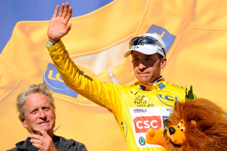 Carlos Sastre recibió la camiseta amarilla de manos del actor Michael Douglas (izq.), el 23 de julio de 2008. / EFE