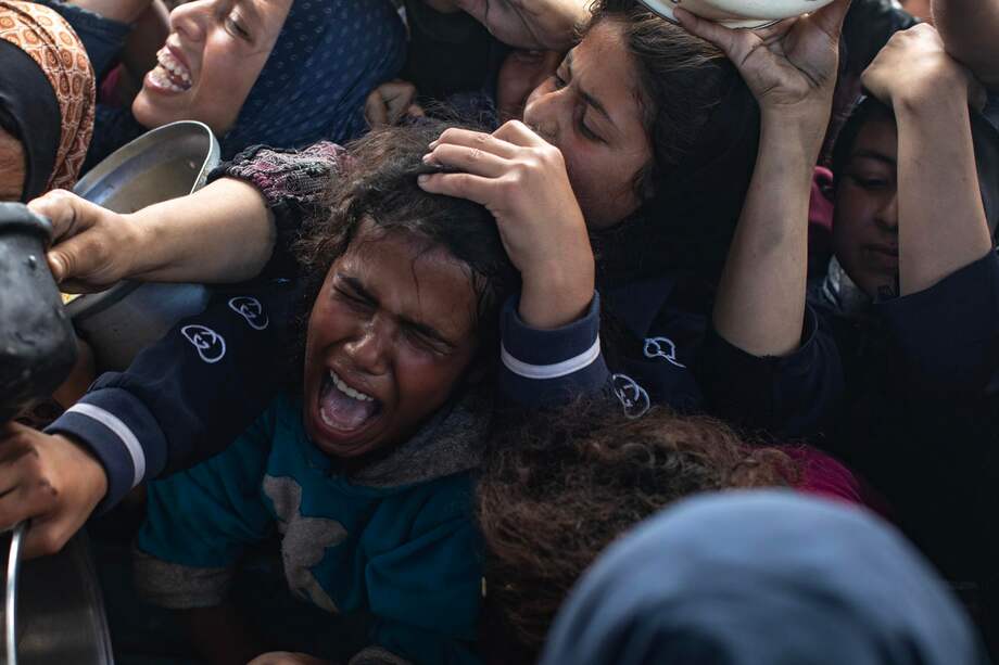 Palestinos desplazados internos hacen fila para recibir una porción de comida de un comedor benéfico en Khan Yunis, al sur de la Franja de Gaza.