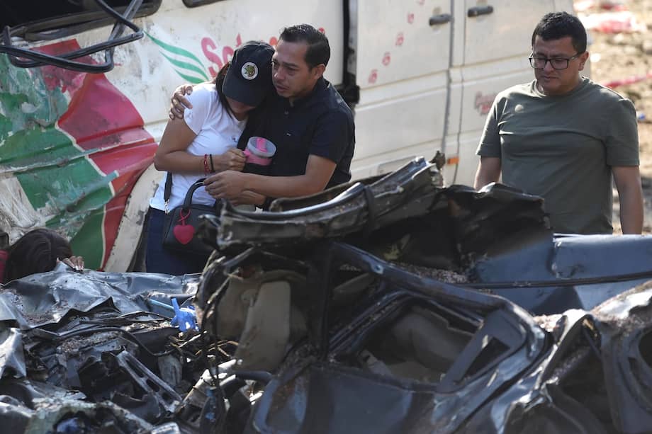 Familiares de las víctimas del atentado ocurrido en la Vía Panamericana lloran este domingo frente a los escombros de los vehículos destruidos en Cajibío (Colombia).