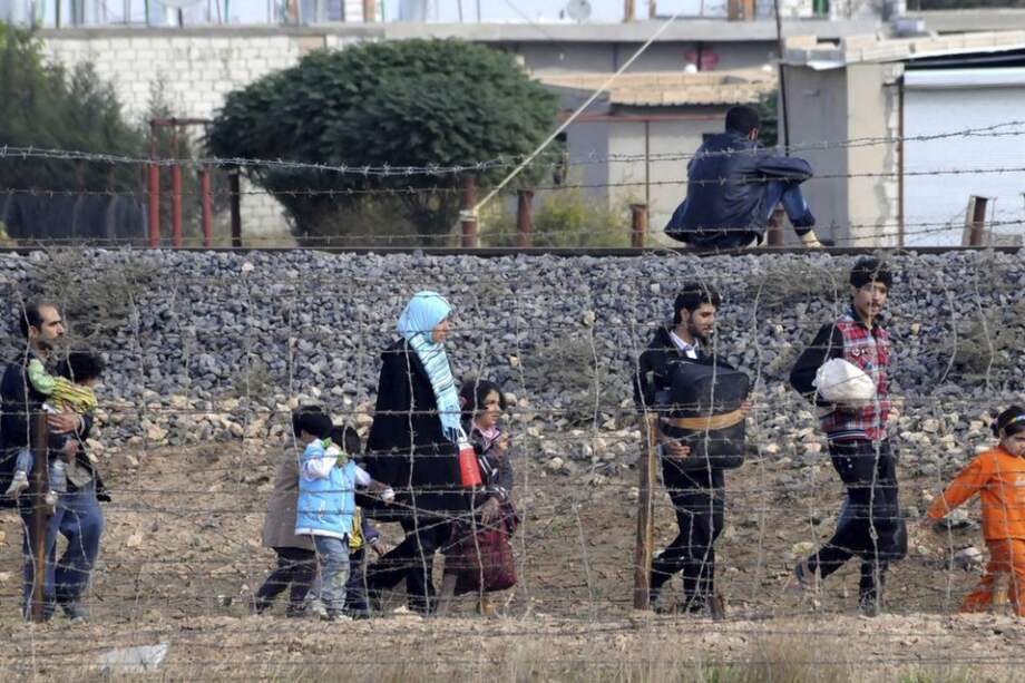 Una familia siria escapa de un bombardeo aéreo en la ciudad fronteriza turca de Ceylanpinar/ EFE