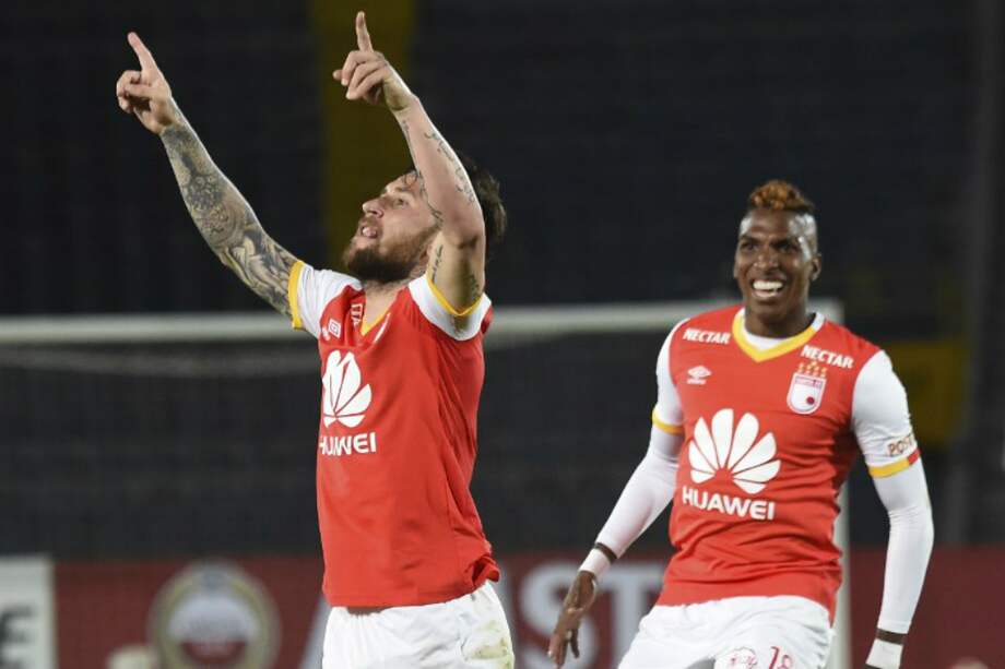 El argentino Jonathan Gómez celebra uno de los dos goles que convirtió este jueves, junto al otro anotador, Johan Arango. / AFP