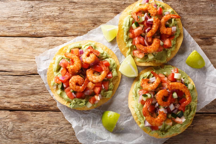 Añade queso rallado a estas tostadas de camarón con pico de gallo de mango.