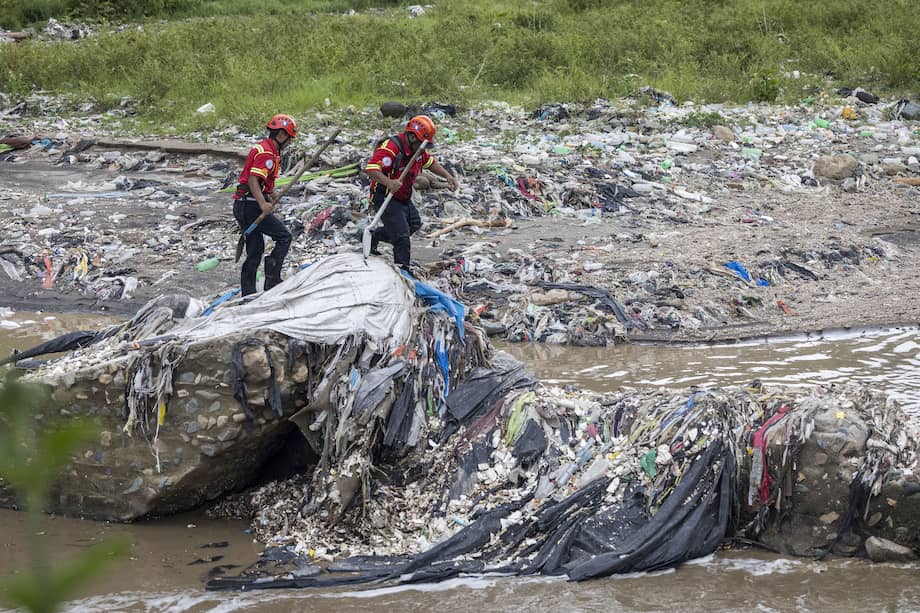 Bomberos trabajan para recuperar los cuerpos de víctimas que fueron arrastradas por el desbordamiento de un río, en el lecho del Río Las Vacas, a varios kilómetros de las viviendas soterradas en el asentamiento Dios es Fiel, hoy en Chinautla, en Ciudad de Guatemala.
