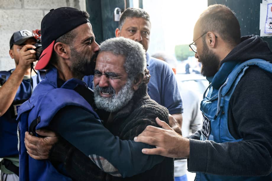 El camarógrafo palestino Mohammed Alaloul (izq.) abraza a su padre después de que dos de sus hijos y su hermano murieran en un ataque israelí contra el campo de refugiados de Al-Maghazi en Deir Balah, en el centro de la Franja de Gaza, frente al hospital de Al-Quds en el mismo ciudad el 5 de noviembre de 2023.