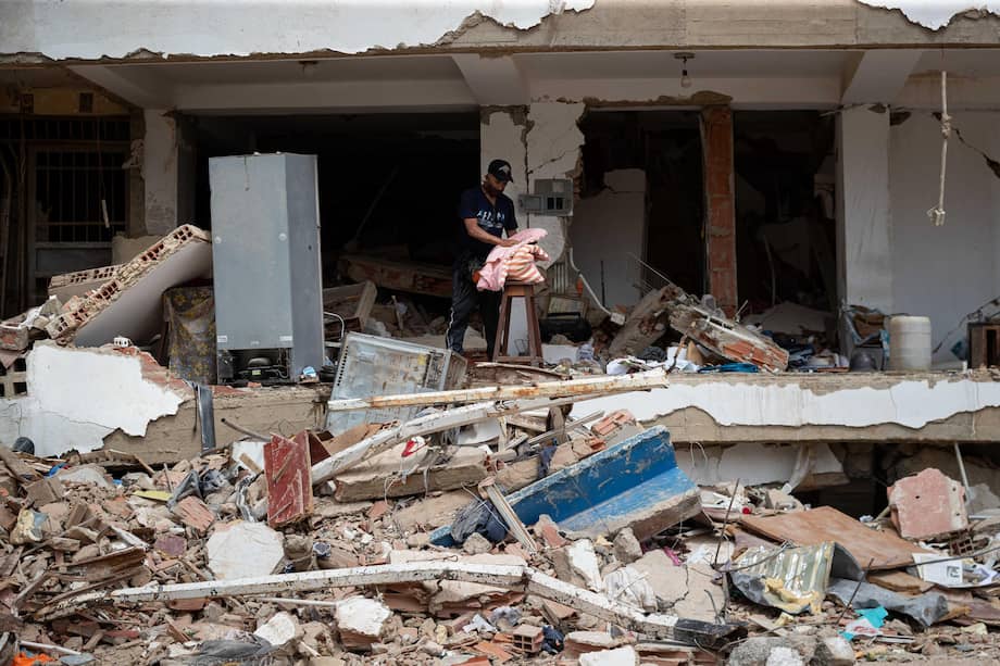 Una persona busca sus pertenencias en medio de los escombros de un edificio destruido por los terremotos en La Guaira (Venezuela).