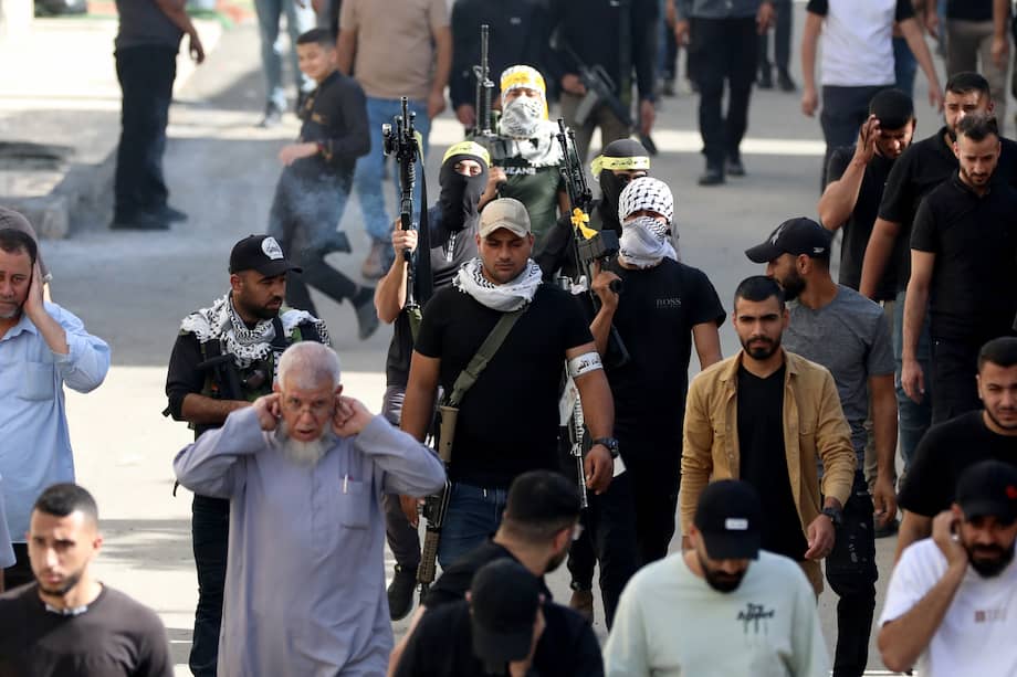 Militantes palestinos asisten a una procesión fúnebre en el campo de refugiados de Yenín, un día después de que 14 palestinos murieran en un ataque israelí, cerca de la ciudad cisjordana de Yenín.