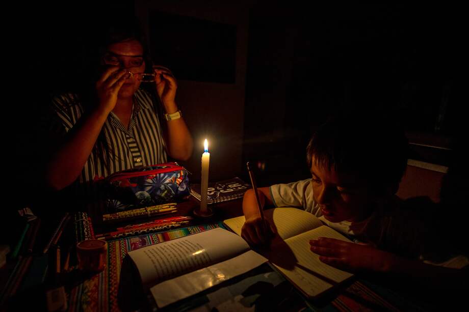 Una madre y su hijo estudian a la luz de la vela en Quito (Ecuador).