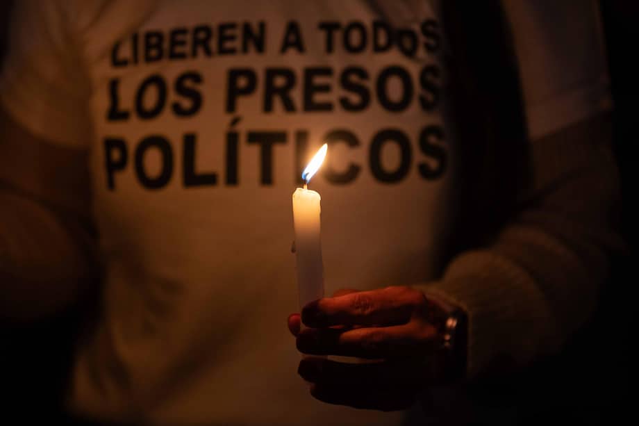 Una persona sostiene una vela en una vigilia frente al centro penitenciario Rodeo I, en el estado venezolano de Miranda.