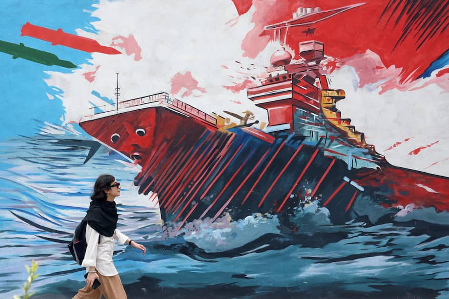 Una mujer pasa junto a un grafiti antiestadounidense en Teherán mientras Estados Unidos mantiene por novena noche consecutiva sus ataques contra objetivos militares iraníes, en medio de la escalada del conflicto por el estrecho de Ormuz.