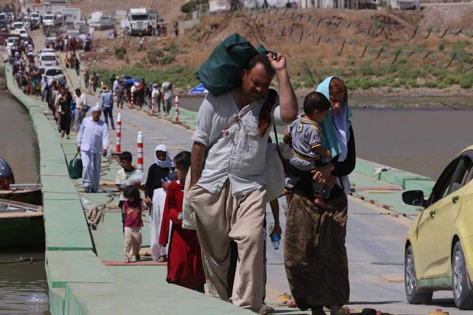 Foto de archivo del 11 de agosto de 2014. Los iraquíes desplazados de la comunidad yazidí cruzan la frontera sirio-iraquí a lo largo del puente Fishkhabur sobre el río Tigris en el cruce de Fishkhabur, en el norte de Irak.