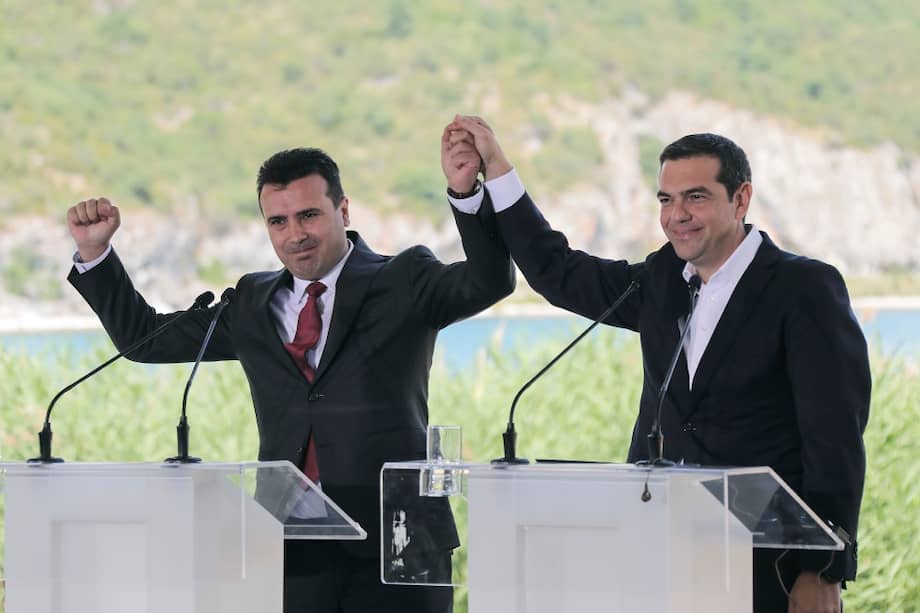 Greek Prime Minister Alexis Tsipras, right and his Macedonian counterpart Zoran Zaev, raise their hands during a signing agreement for Macedonia's new name in the village of Psarades, Prespes Greece, on Sunday, June 17, 2018. The preliminary deal launches a long process that will last several months. If successful, it will end a decades-long dispute between neighbors Greece and Macedonia _ which will be renamed North Macedonia. (AP Photo/Yorgos Karahalis)