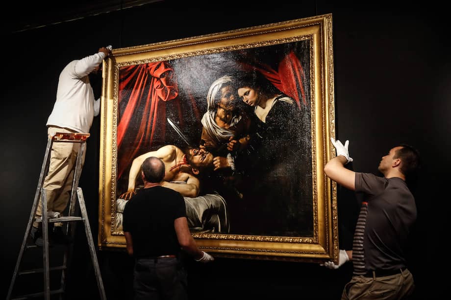 Trabajadores ubican una pintura que algunos expertos creen que es "Judith Beheading Holofernes" de Caravaggio para su presentación pública en el Drouot de París el 14 de junio de 2019, antes de someterse al martillo el 27 de junio en Toulouse, la ciudad donde fue descubierta. hace cinco años. / Francois Guillot - AFP