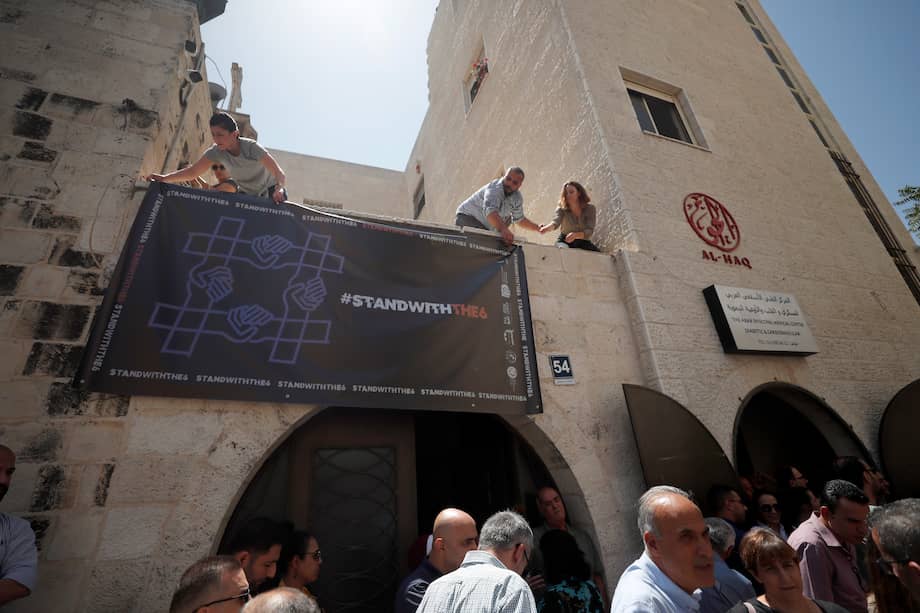 Activistas palestinos cuelgan una pancarta pidiendo solidaridad con las seis organizaciones de la sociedad civil en la oficina central de Al Haq en la ciudad cisjordana de Ramala.