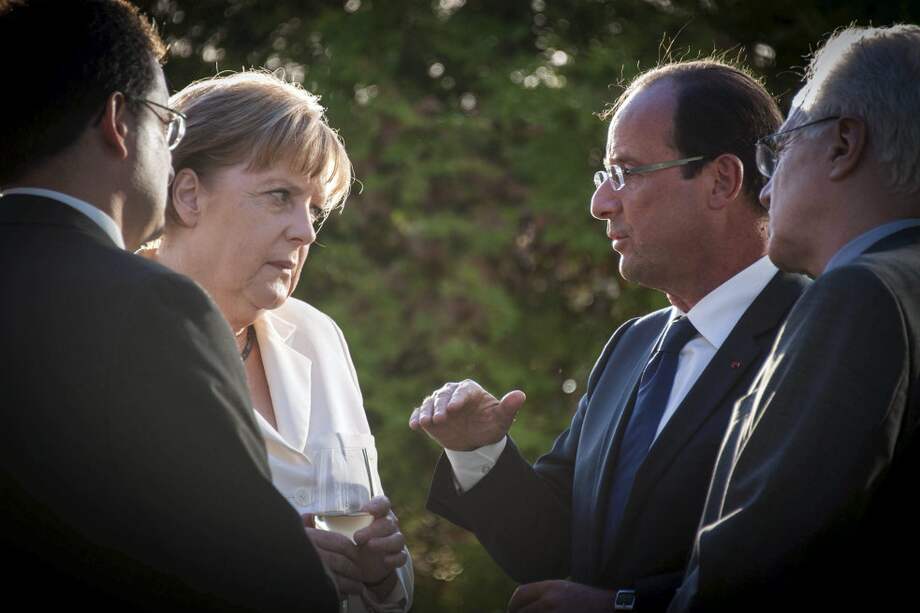 Ángela Merkel, canciller de Alemania, dialoga con François Hollande, presidente de Francia. / EFE