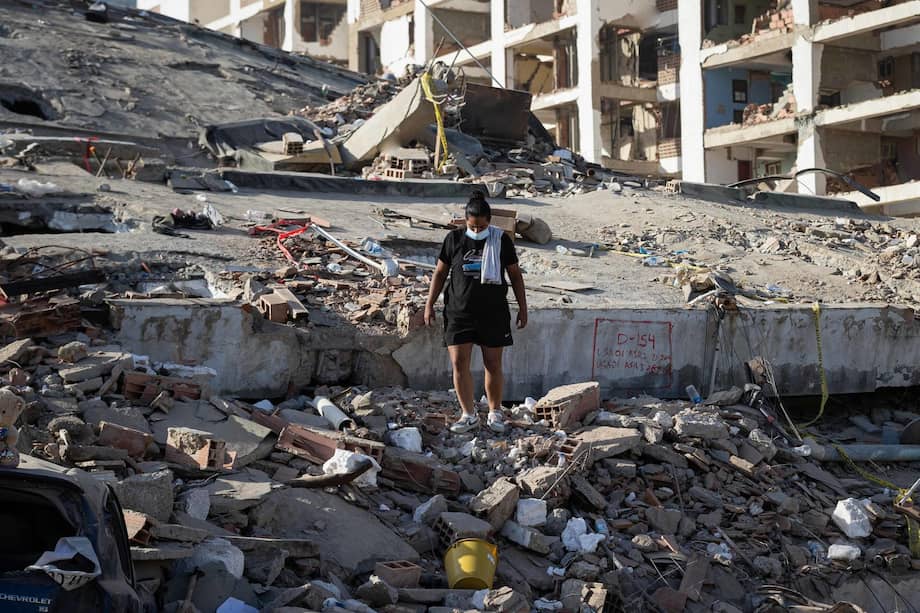 Una mujer camina sobre los escombros de un edificio en La Guaira (Venezuela).