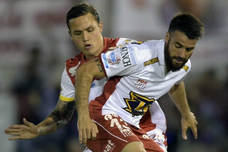Luis Manuel Seijas (atrás) ante el defensor Jose San Roman en el partido de la final contra Huracán. / EFE