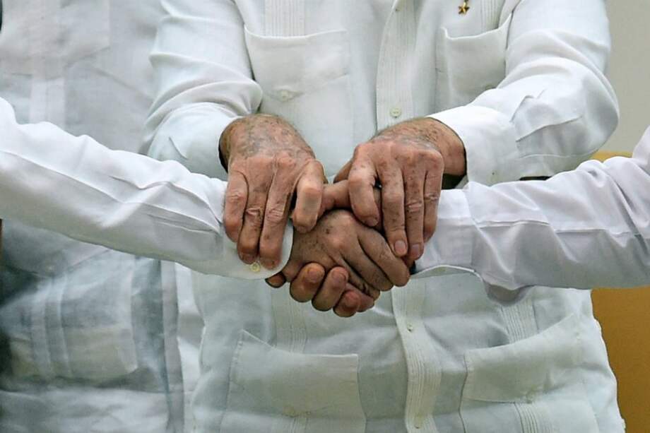 Detalle del saludo de Juan Manuel Santos y “Timochenko” el pasado 23 de septiembre en La Habana, Cuba. / AFP