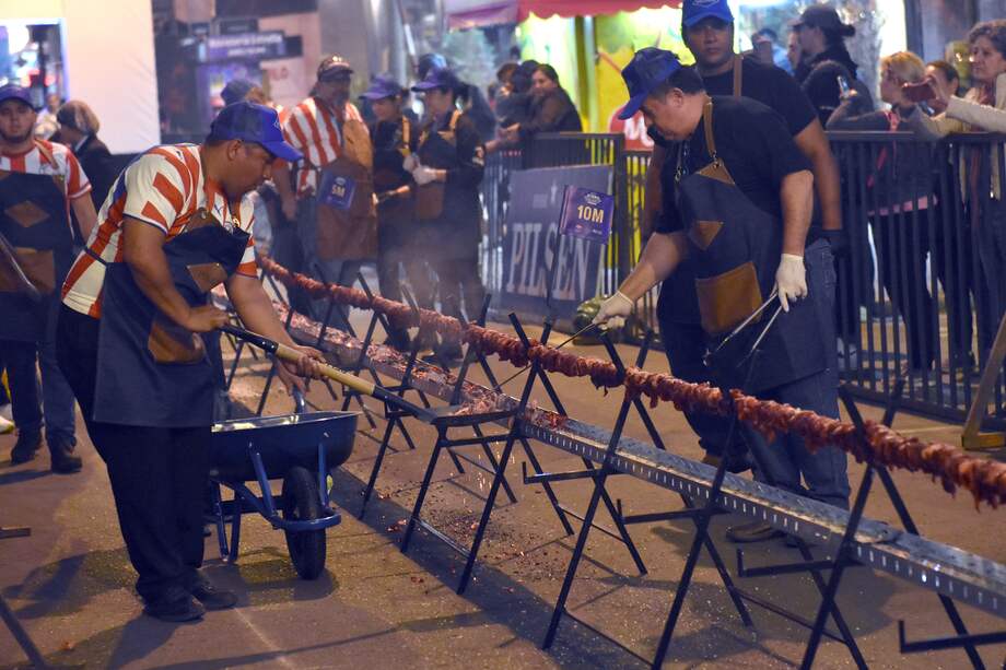 AME6555. ASUNCIÓN (PARAGUAY), 30/07/2023.- Fotografía que muestra cocineros mientras verifican la cocción del "asadito" mas largo del mundo, realizado el 29 de julio de 2023 en Asunción (Paraguay).