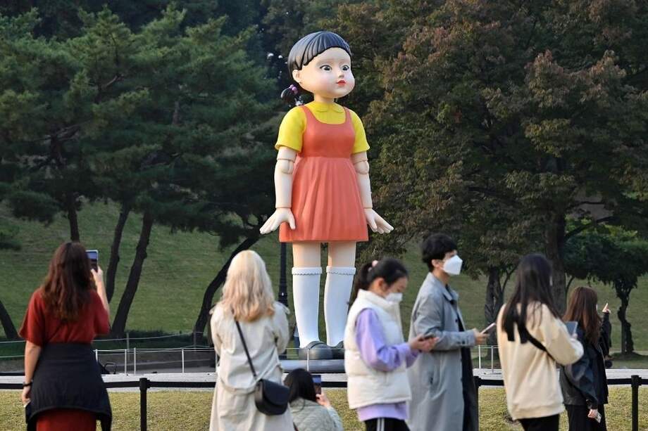 Un grupo de personas se reúne frente a un modelo de la muñeca llamada 'Younghee', que aparece en la serie de Netflix "El juego del calamar".