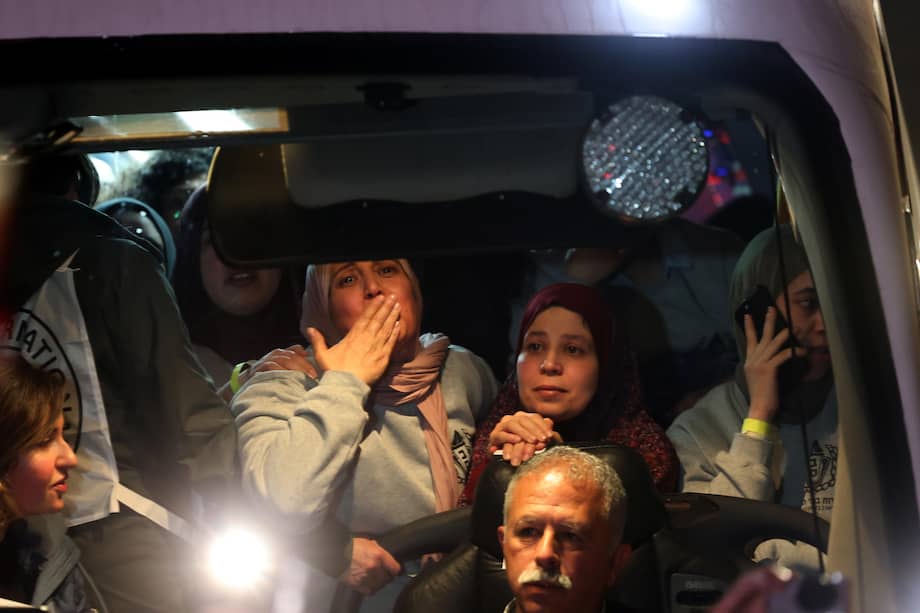 Las personas a bordo de un autobús que transporta a prisioneros palestinos liberados de la prisión militar israelí de Ofer hacen un gesto a su llegada a Ramallah