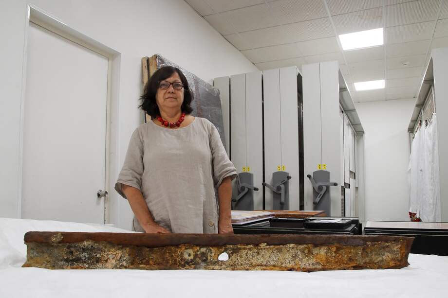 María Luisa Ortiz, jefa de colecciones del Museo de la Memoria y los Derechos Humanos, muestra un riel oxidado cubierto de restos de moluscos, una cuerda y un perno, parte de Las escasas pruebas de las prácticas dictatoriales de Augusto Pinochet.